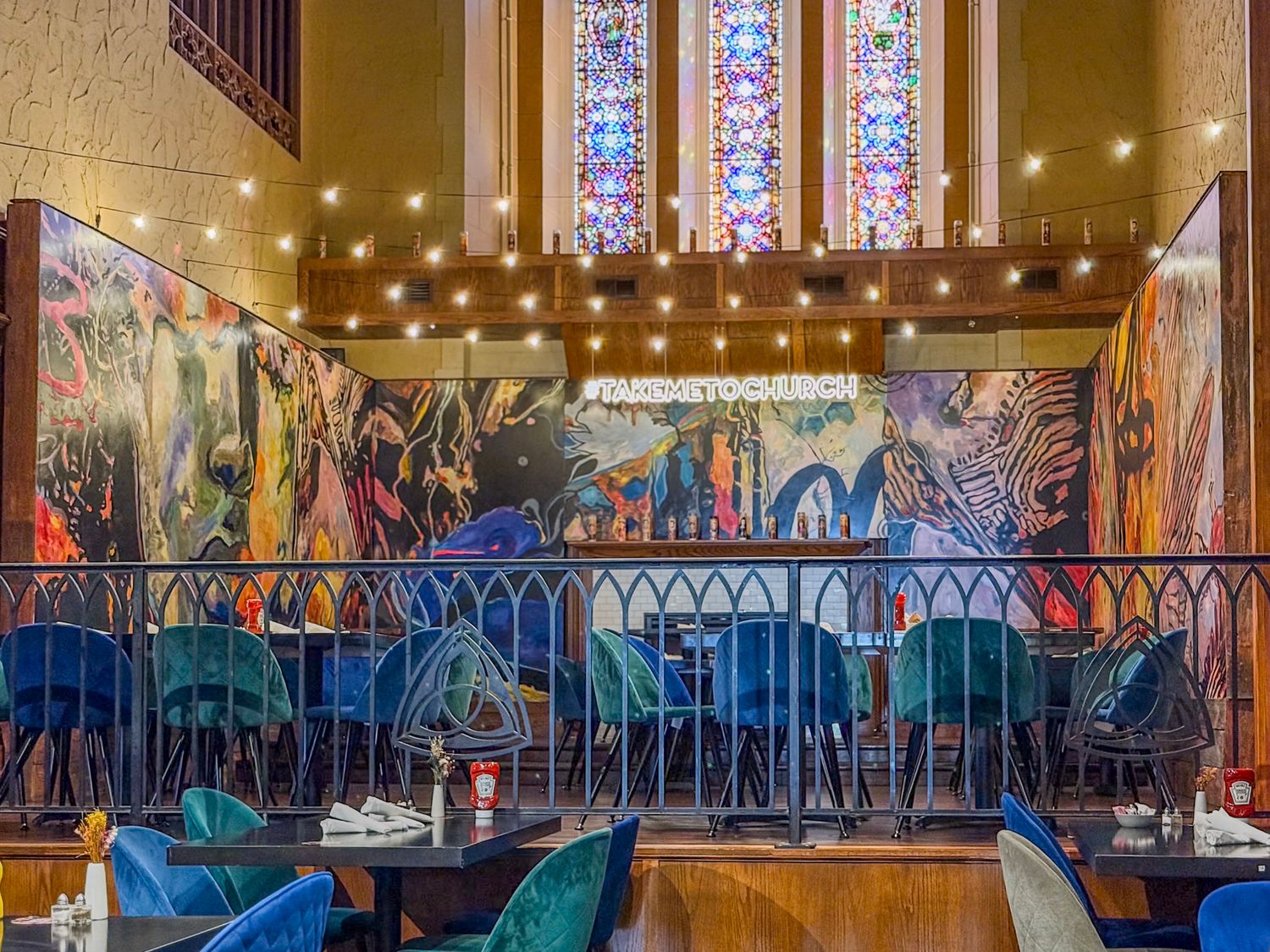 Church interior with stained glass windows and string lights creating an elegant ambiance.