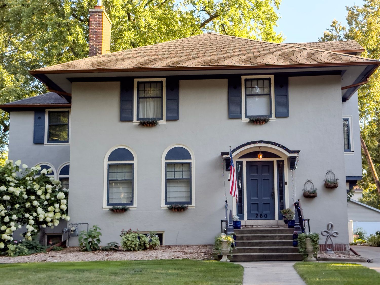 Ranch-style homes with white exterior, dark shutters, and landscaped front yards.