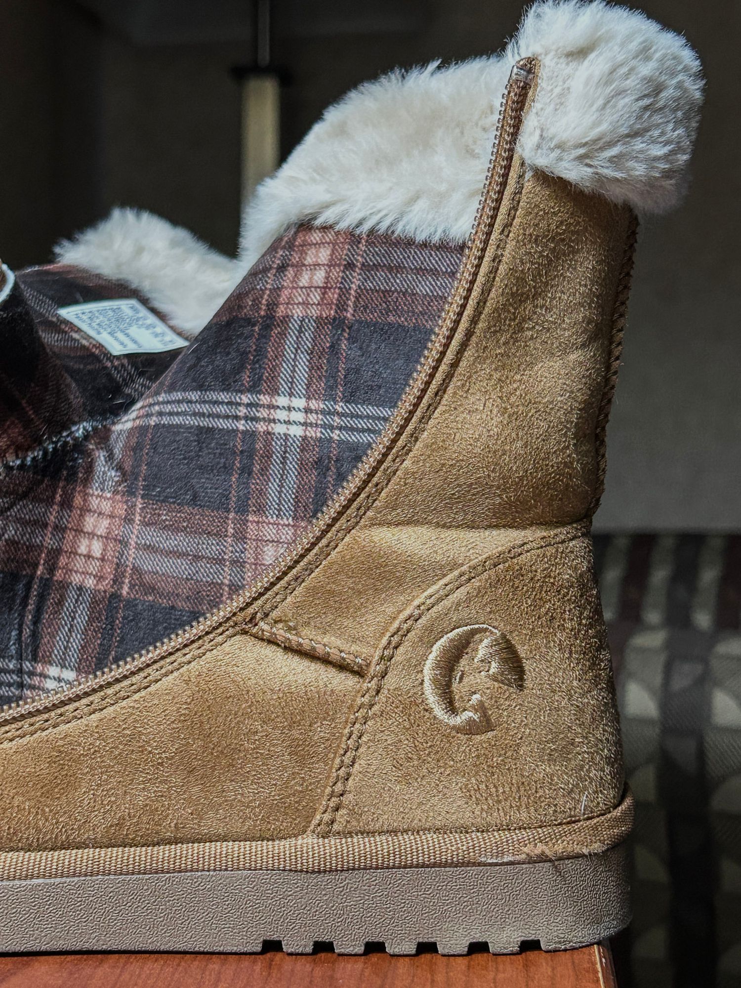 Winter boot featuring plaid fabric detail and suede material with brand logo.
