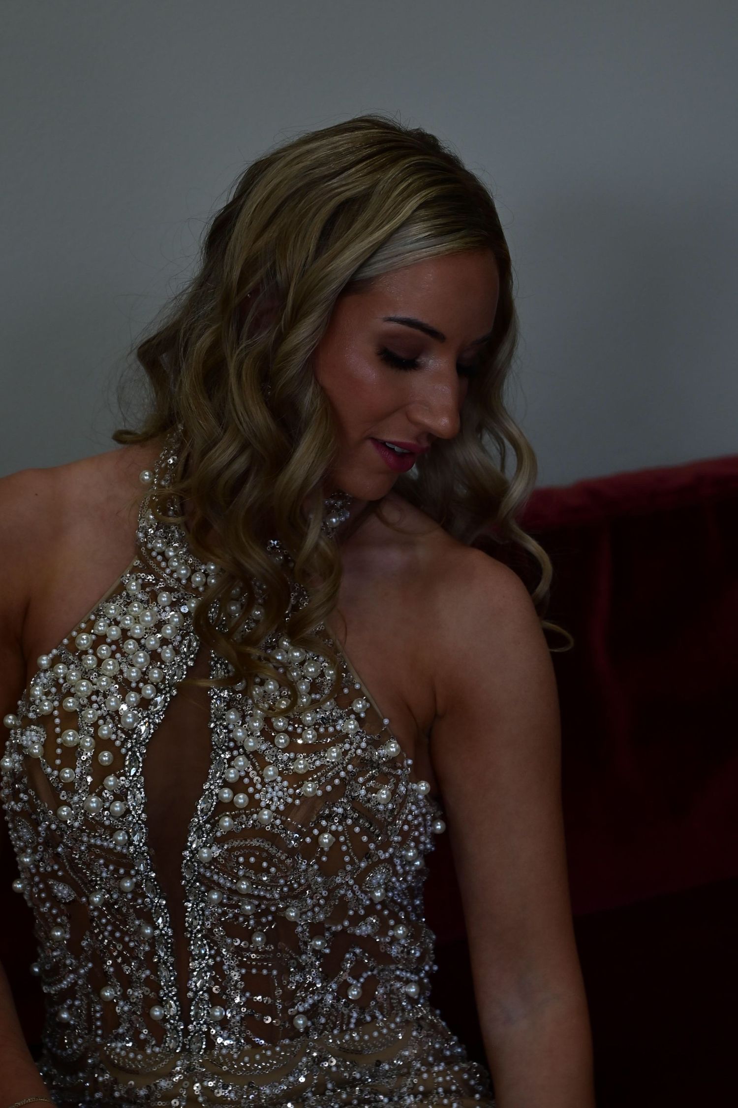A person wearing a sparkling crystal-embellished evening gown laughs joyfully in a candid photo series.