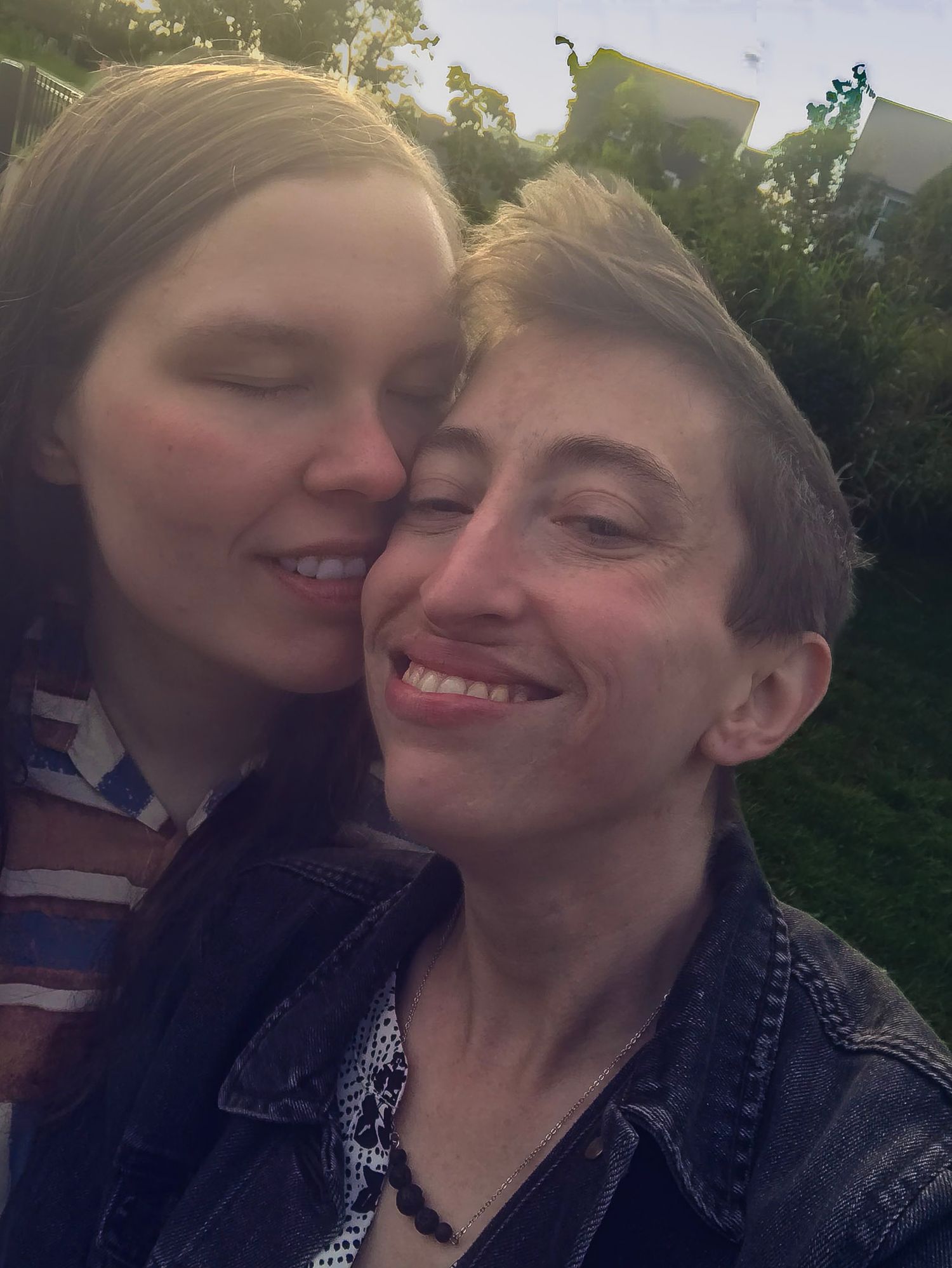 Two people sharing an intimate moment outdoors at sunset.