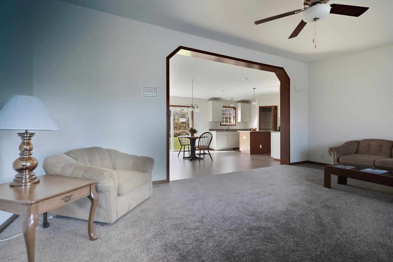 Empty room interior with grey carpet flooring, white walls, and ceiling fan showing multiple angles of the space.