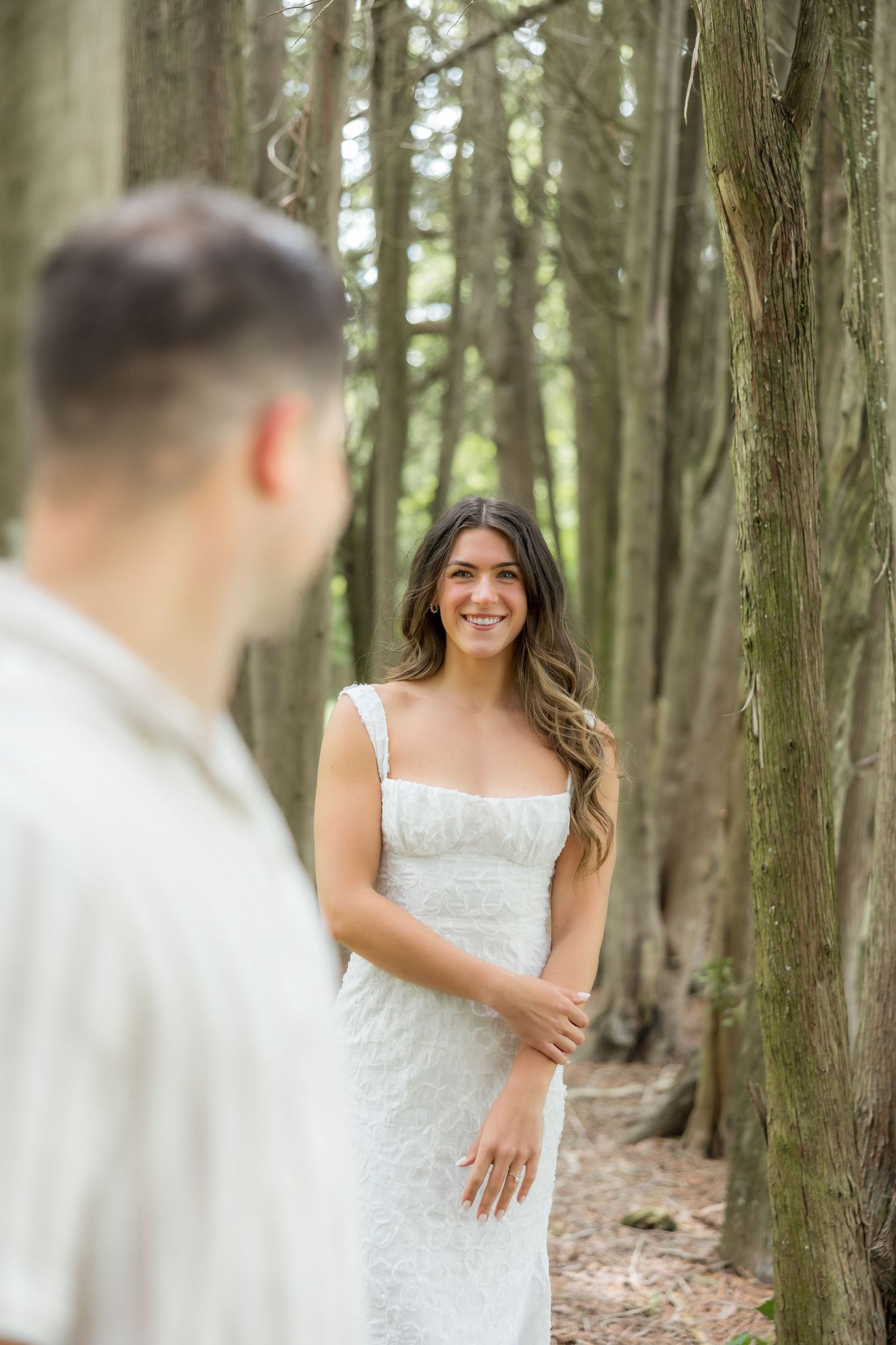 Bride in white lace dress smiling in a forest setting during an engagement session near Pittsburgh pa with Edward Jacob photography.