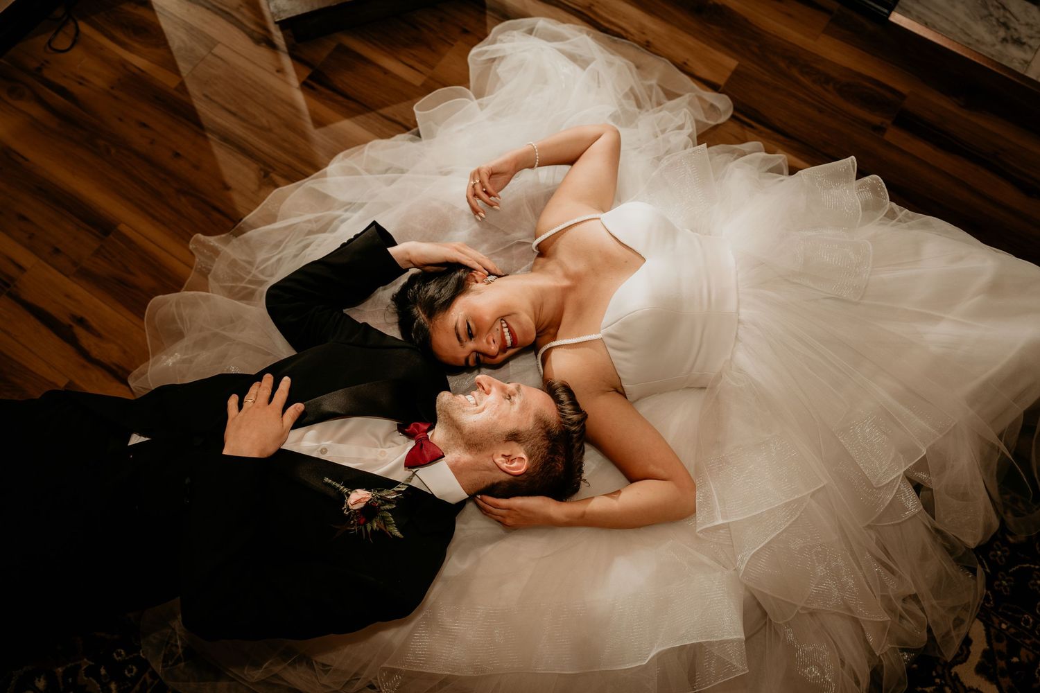 Husband and wife laying on the ground staring into eachother's eyes in Seattle WA on their wedding day.