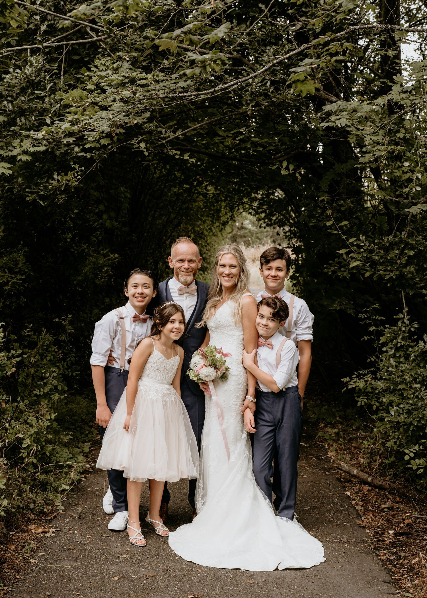 Bride and groom pose with their family in Seattle Washington at Discovery park on their wedding day. Seattle wedding.