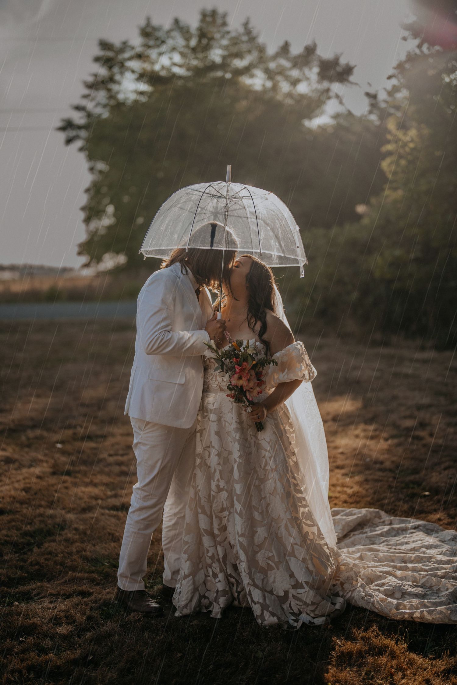 Husband and wife under an umbrella in the rain on their wedding day at Deception Pass Washington