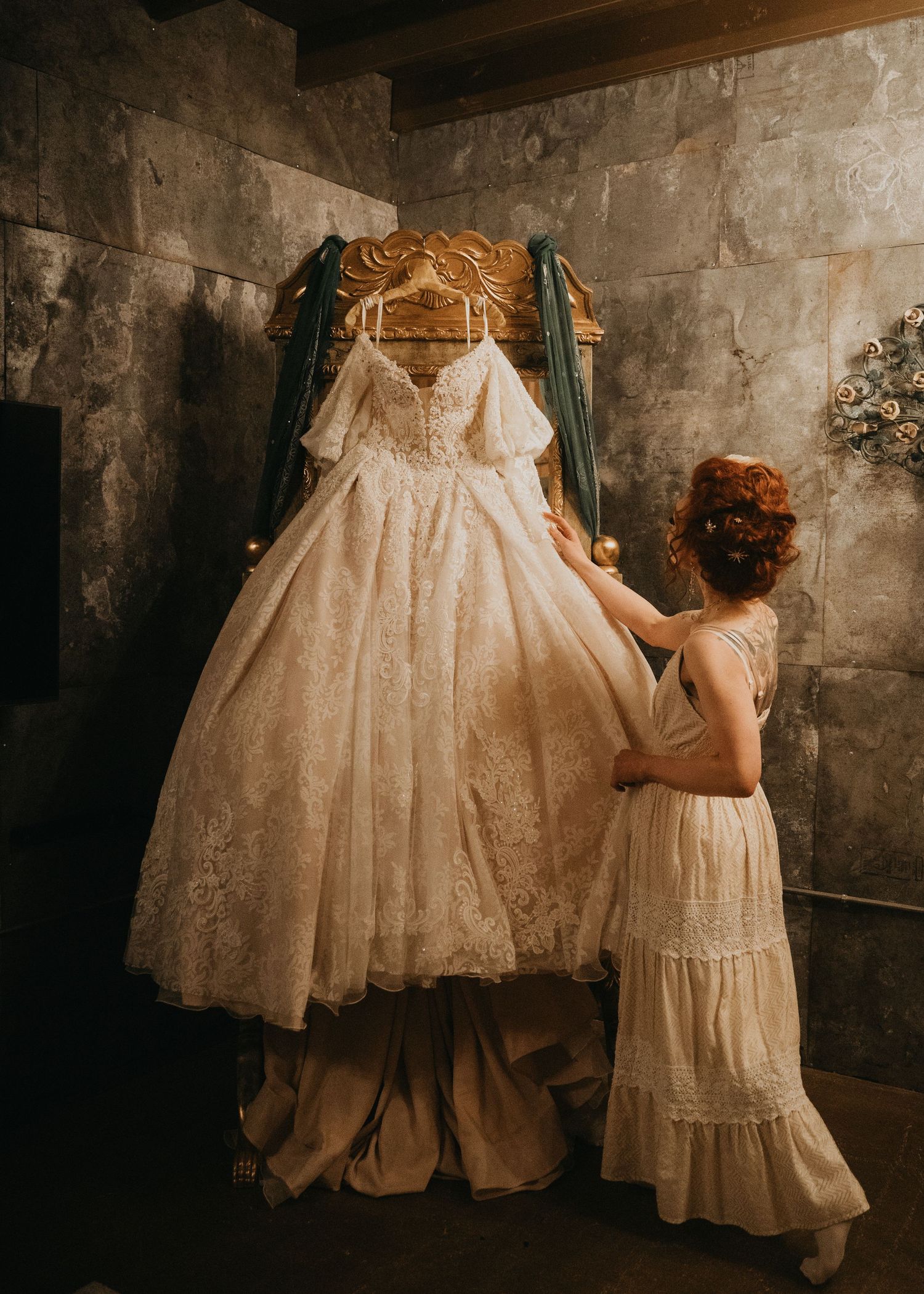Seattle wedding photo bride looking at her dress hanging on in mirror with a Rembrandt look to the photo in Olympia, Washington.