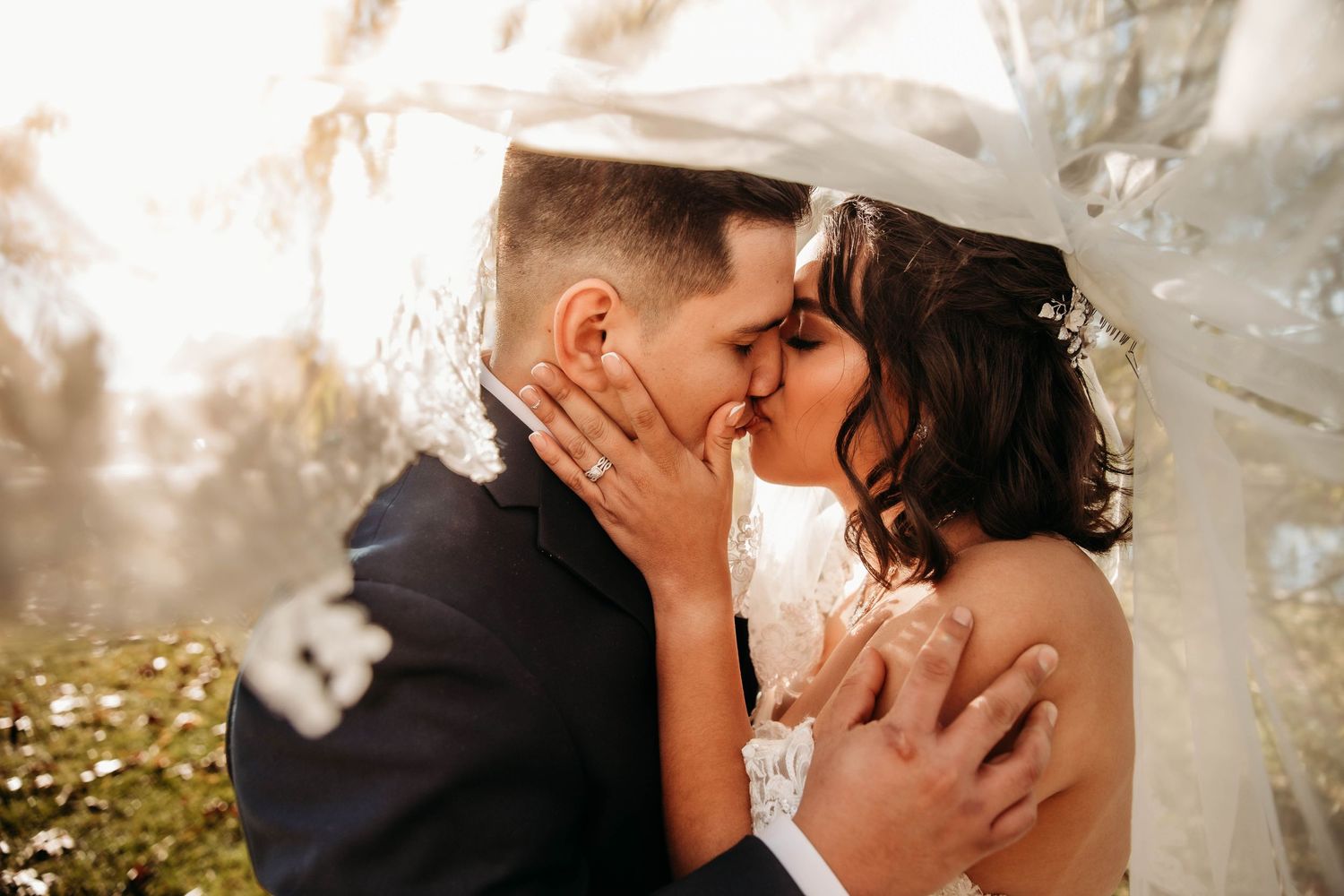 Close-up wedding couple kiss by L. Ballenger Photography. Professional Branson MO wedding photographer capturing authentic moments.