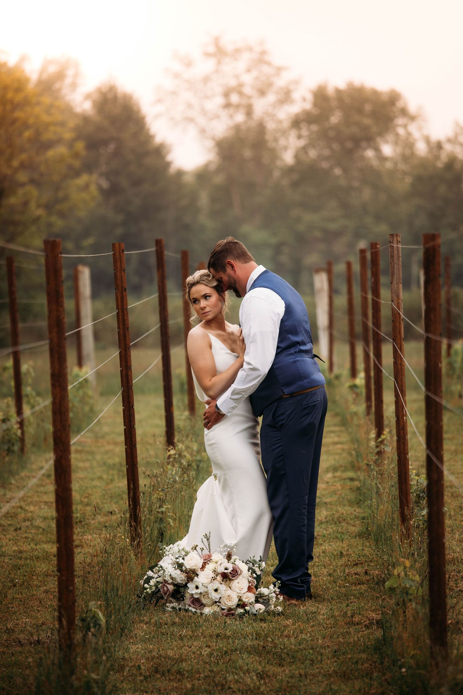 Branson Wedding Photographer conducting a photo session of the bride and groom in the vinyards with moody vibes.