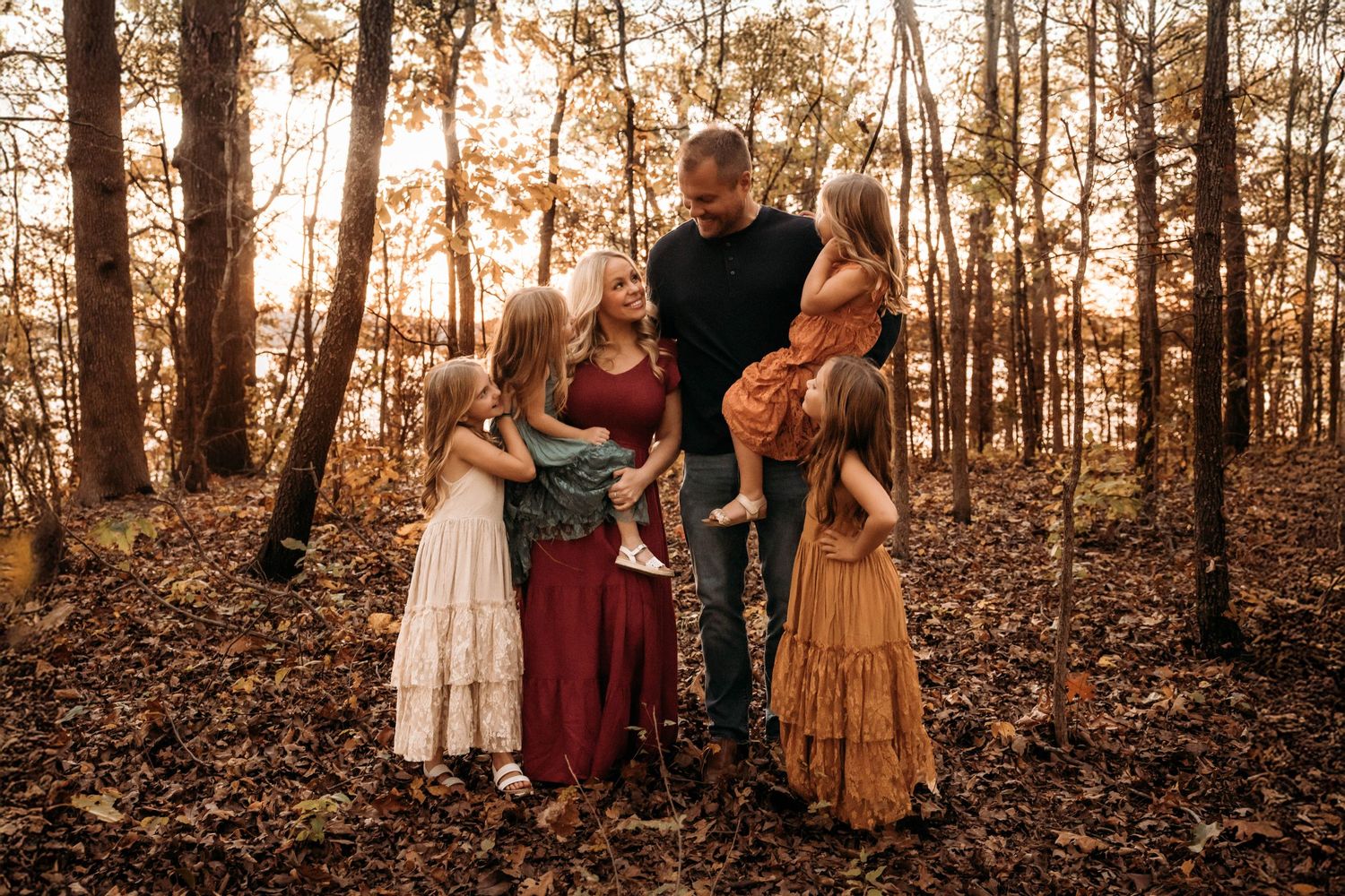 Family of six in fall outfits during an outdoor autumn photo session in the Branson, Missouri woods.