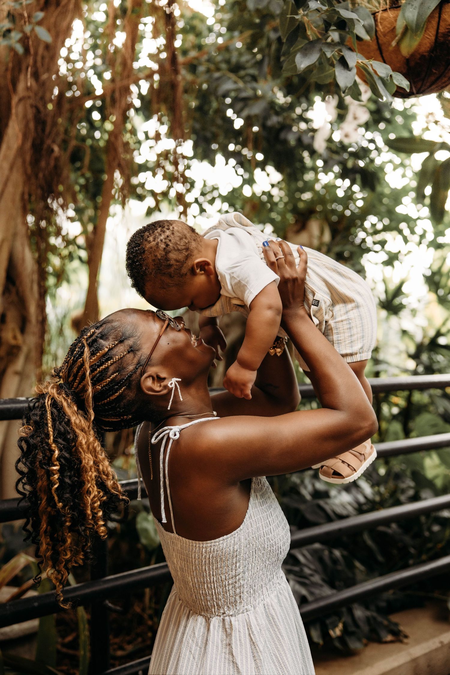 Mother and baby during a lifestyle photo session at a lush indoor tropical garden in Branson, MO.