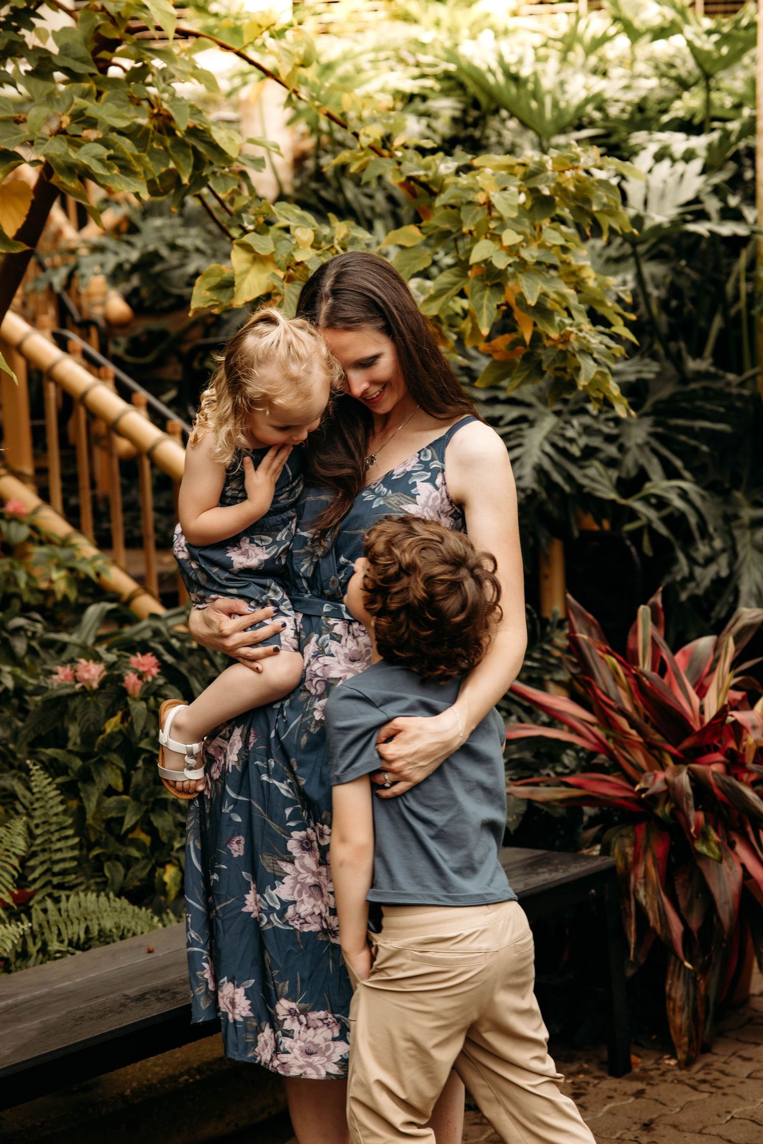 Mother and children during a lifestyle photo session at a lush indoor tropical garden in Branson, MO.