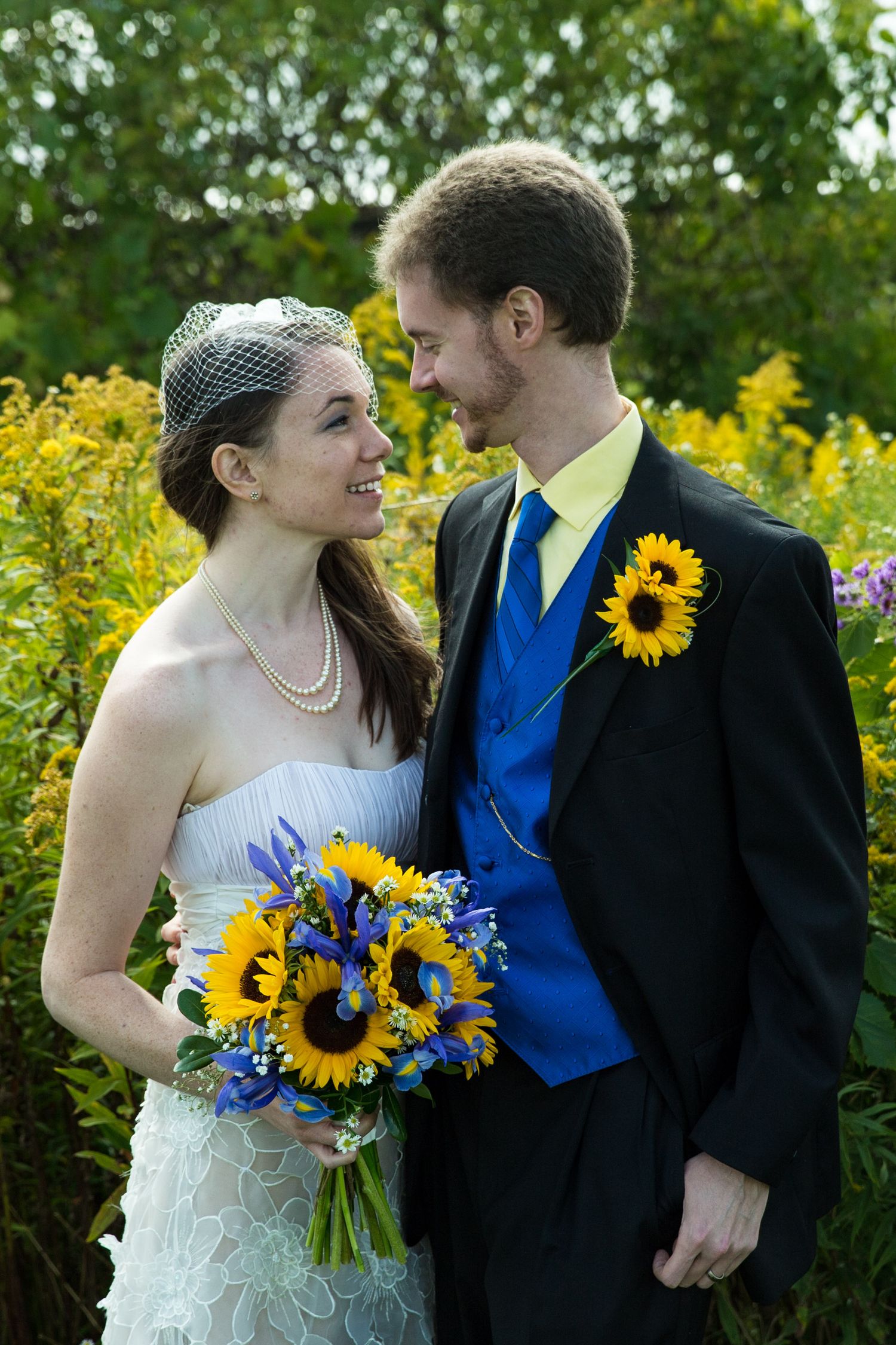 Bride and Groom portrait looking lovingly into each others eyes in a field of yellow flowers