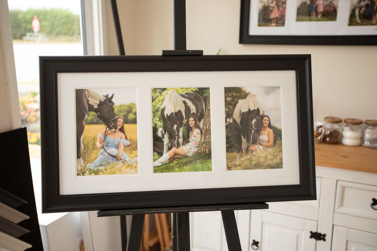 A gallery wall displays framed artwork and photographs in a home interior setting.