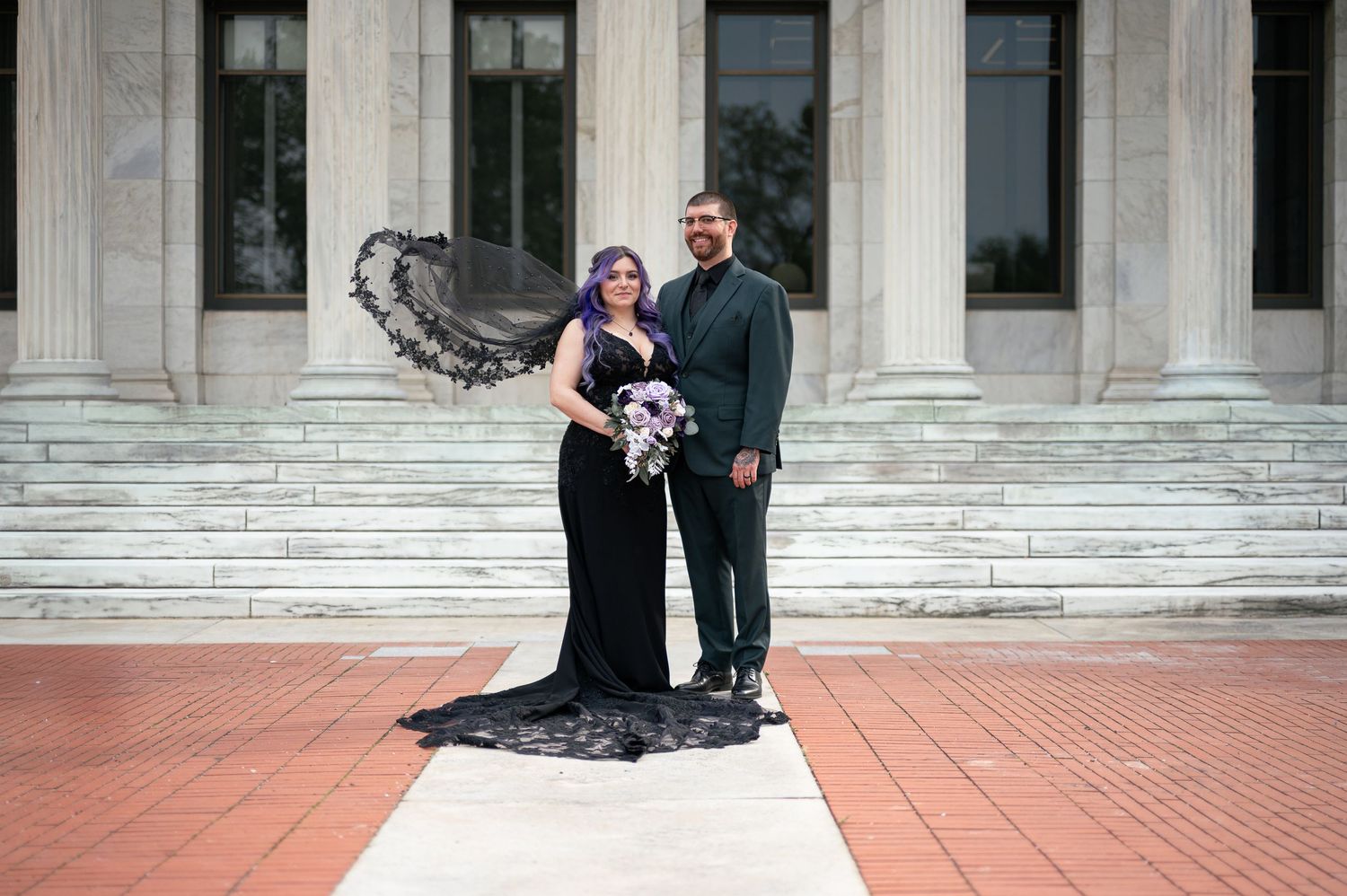 Classical stone columns and steps create an elegant architectural backdrop for wedding portraits in Toledo, Ohio.