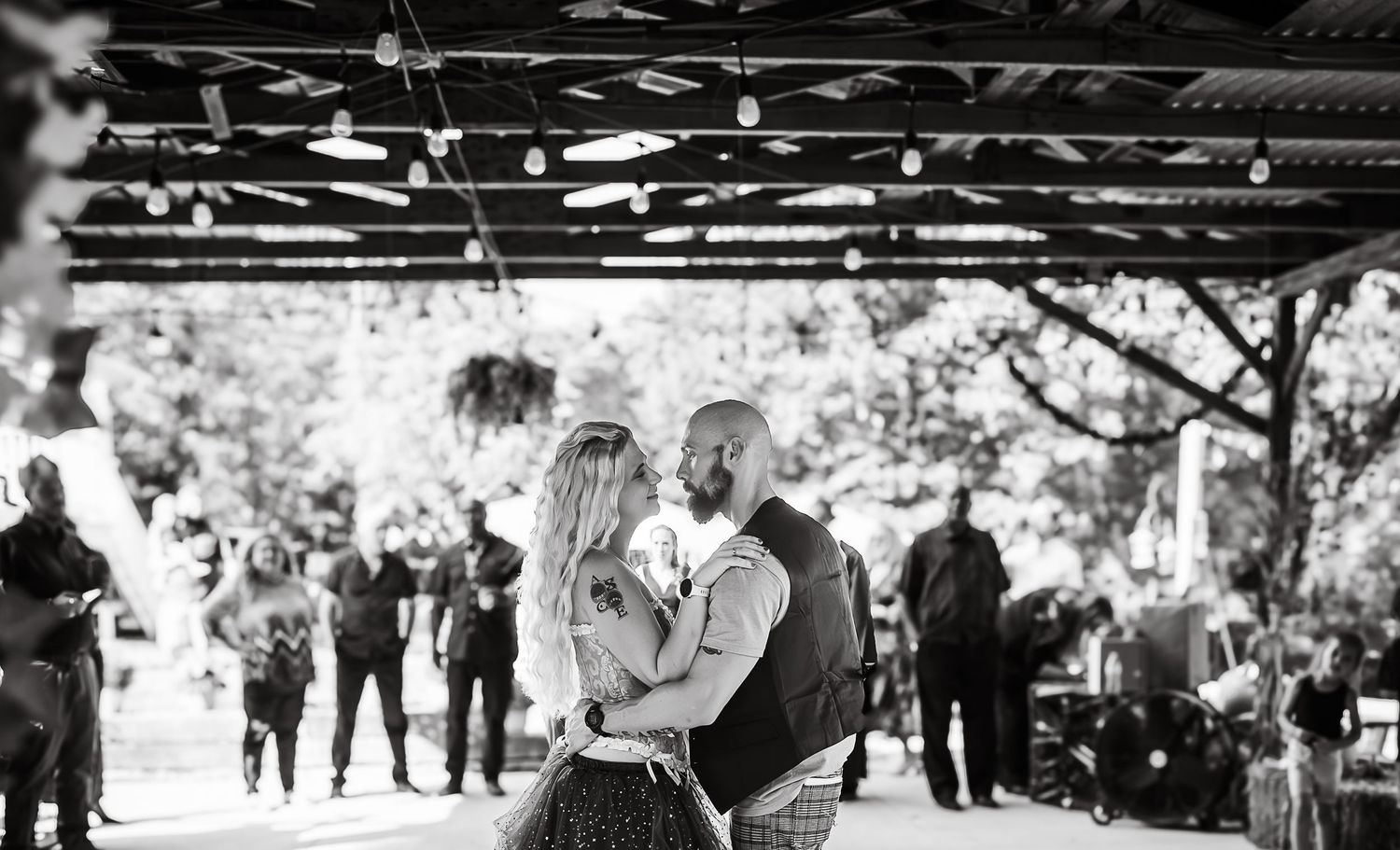 Black and white photo collage showing candid moments from a wedding celebration with dancing and festivities.