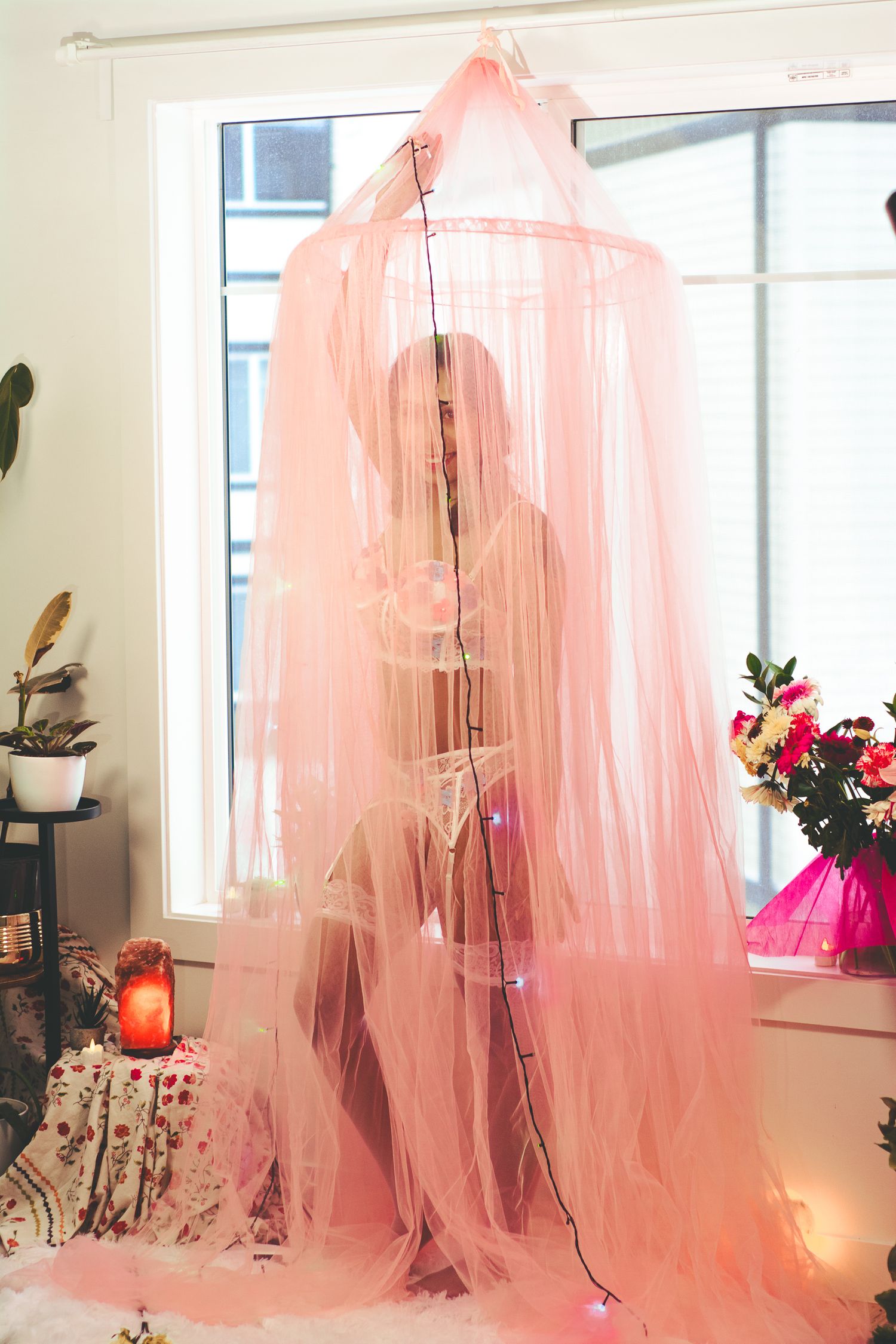 Ethereal pink curtain draping creates artistic shadows and silhouettes in window light.