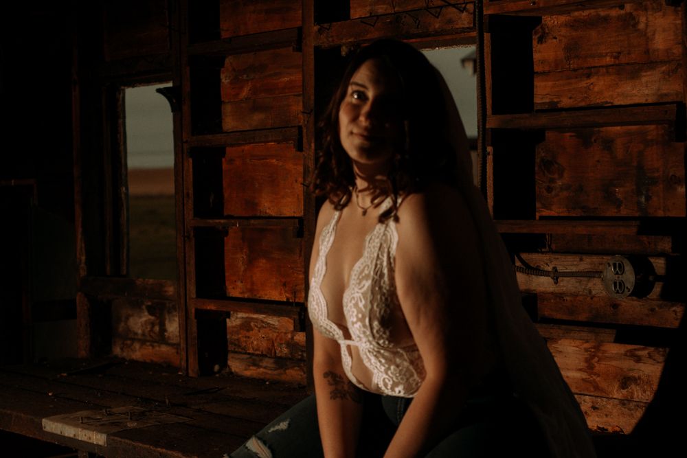 Moody portrait in warm lighting against rustic wooden wall panels.