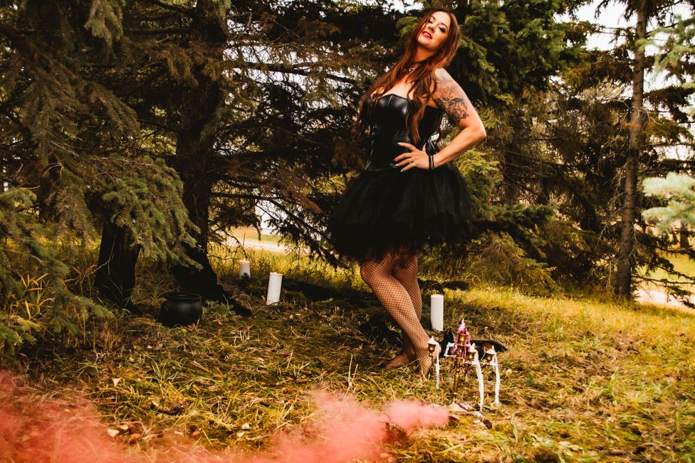 Stylish gothic photoshoot in forest with black dress and autumn scenery.