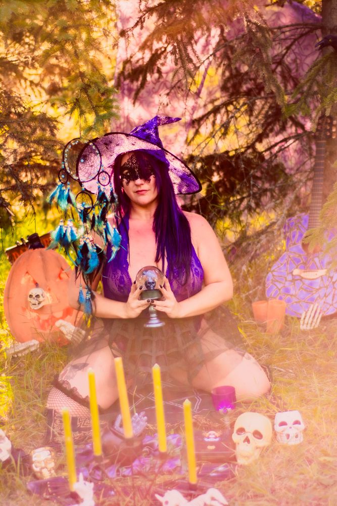 Magical forest setting with witch accessories, crystal ball, pumpkins and yellow candles.
