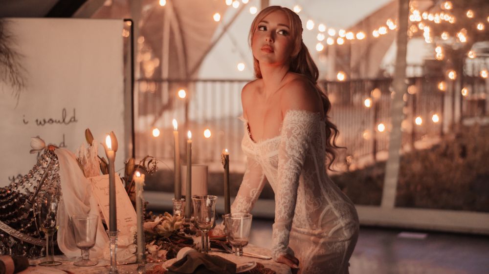 Romantic candlelit table setting with string lights creating an intimate atmosphere.