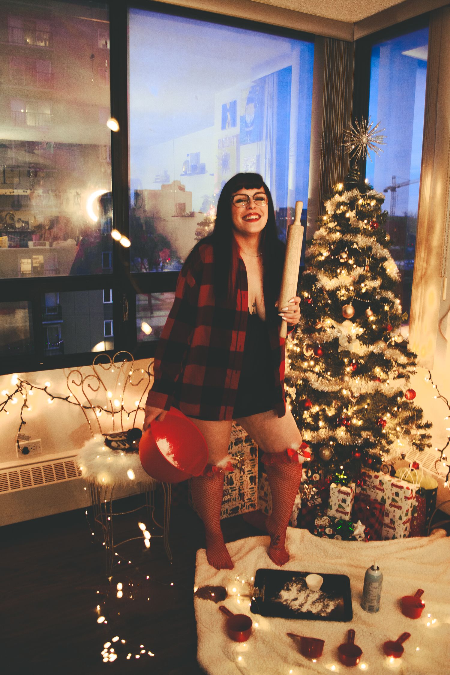Festive holiday photo with buffalo plaid shirt and Christmas decorations.