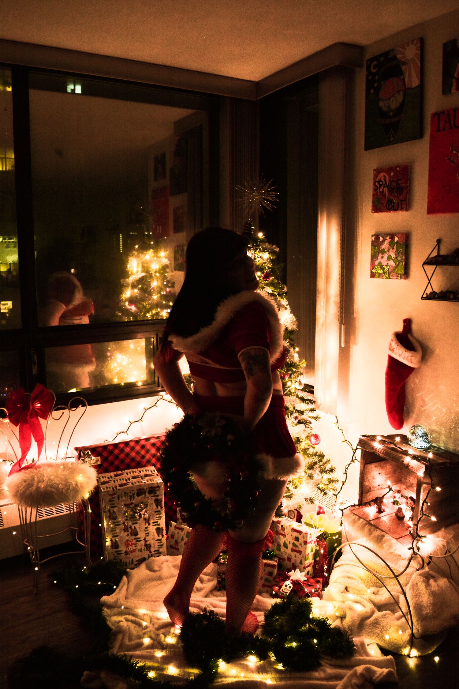 A cozy Christmas scene with twinkling lights and decorations in a dimly lit room.