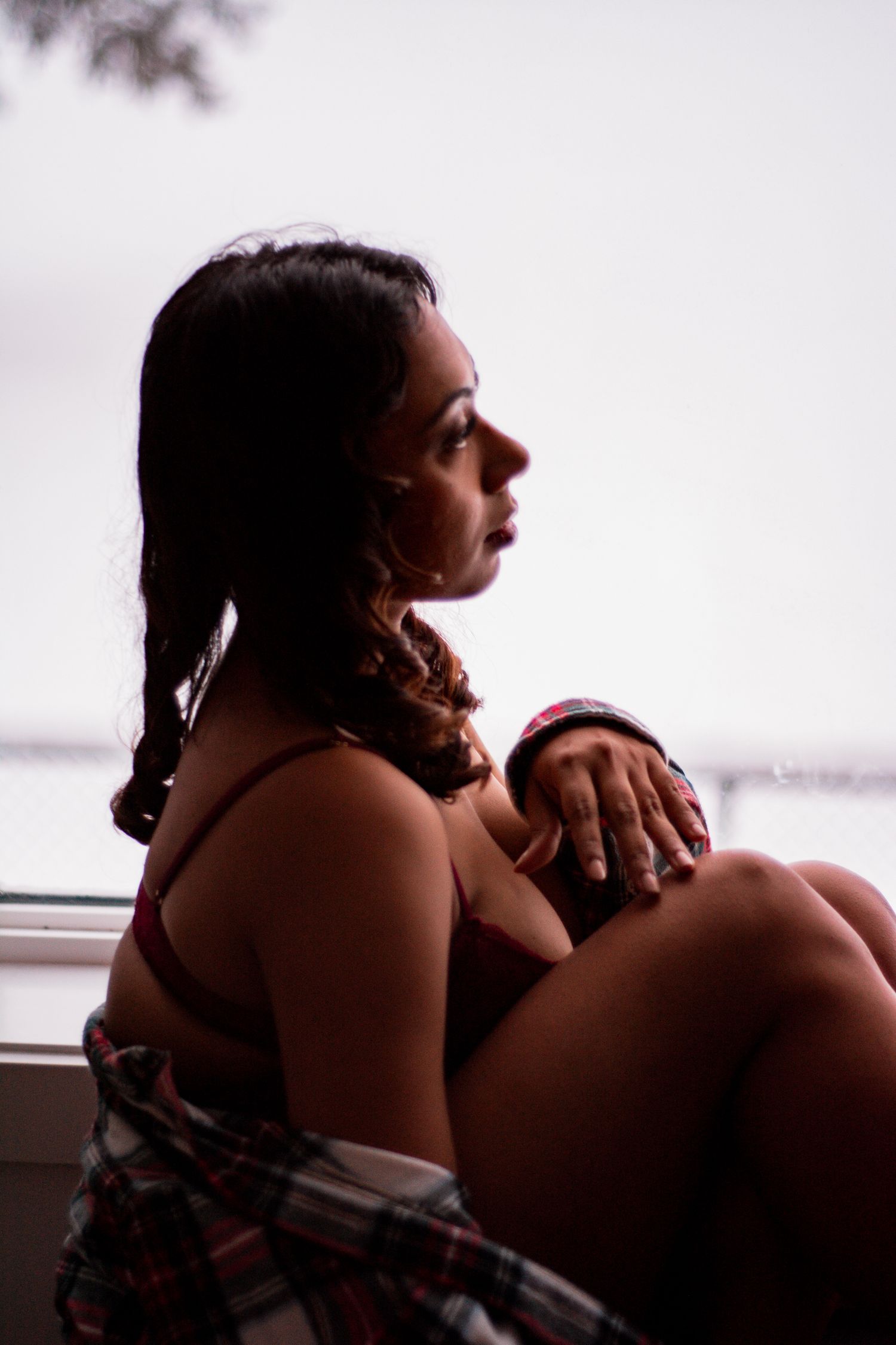 Sensual profile portrait against window with soft natural lighting.