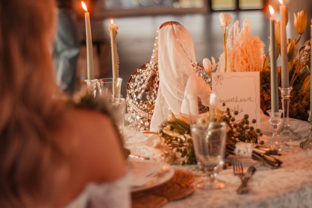 Intimate wedding table setting with candles, dried flowers and elegant place cards.