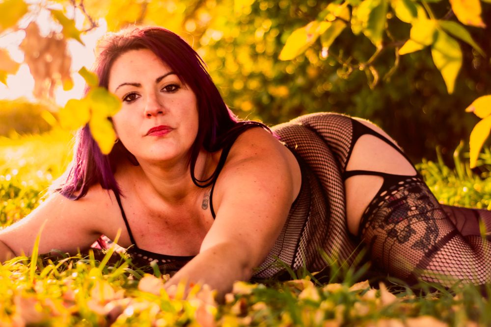 Romantic autumn boudoir photography with delicate lace details and warm lighting.