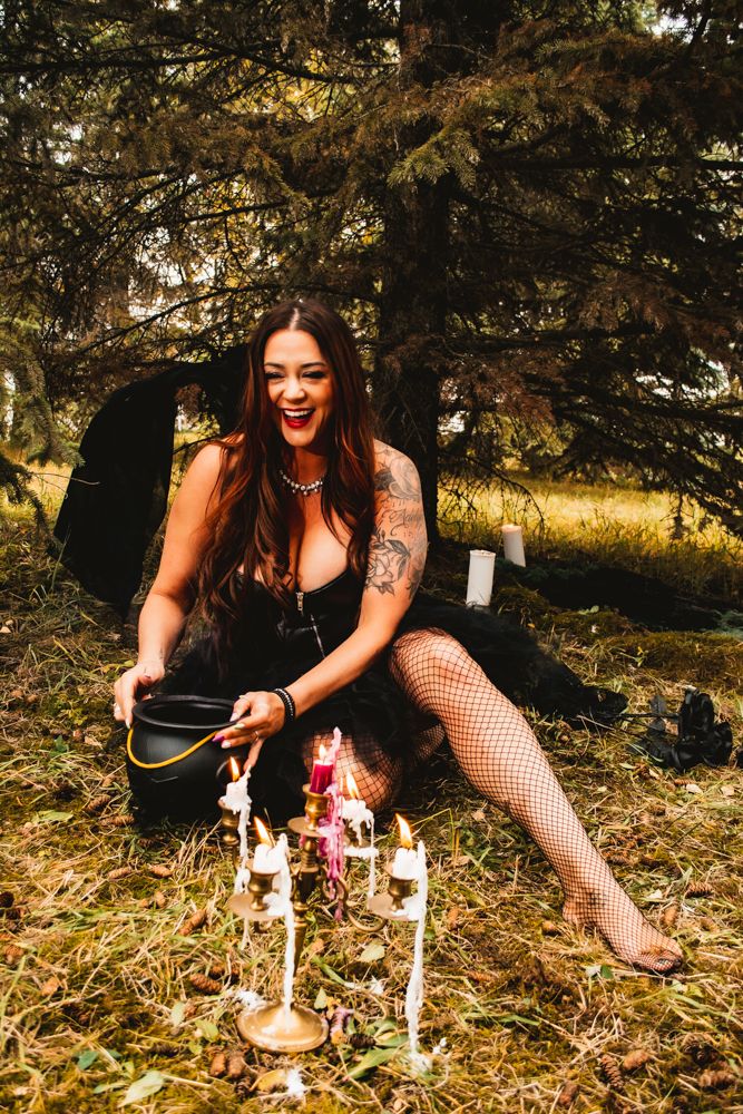 A dark romantic photoshoot with candlelit props and fishnet stockings captures a gothic autumn atmosphere.