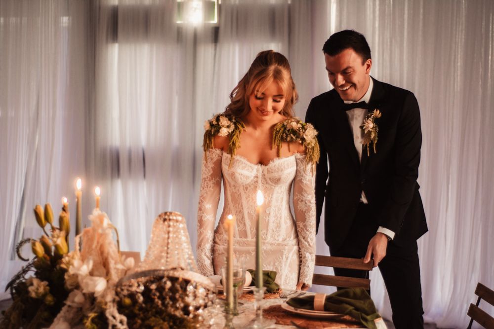 Elegant wedding reception with candlelit table and formal settings.