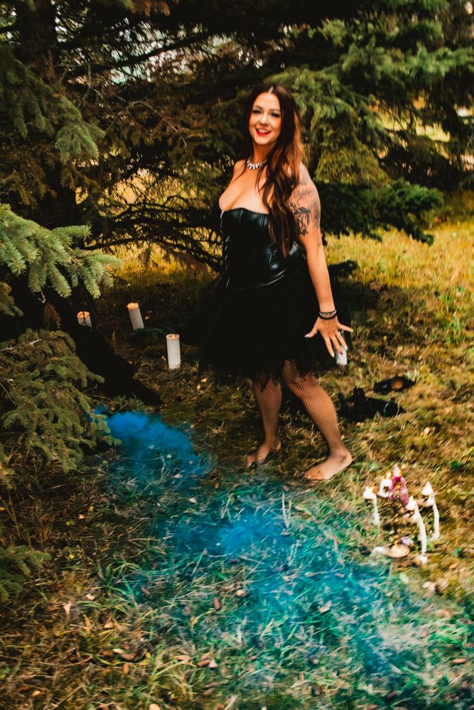 An enchanted forest scene features a black corset dress and magical blue smoke effects.