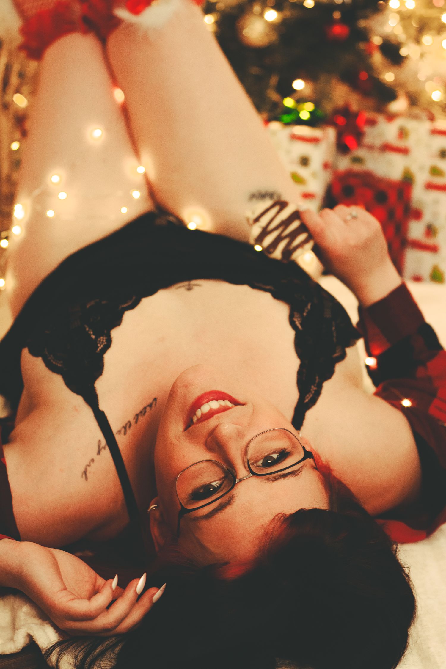 Festive holiday boudoir photo featuring glasses and red lipstick.