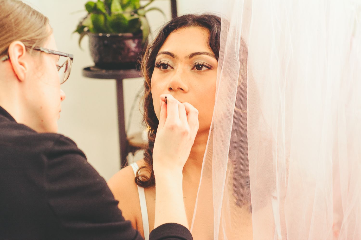 Makeup artist applying finishing touches during a professional photo session.
