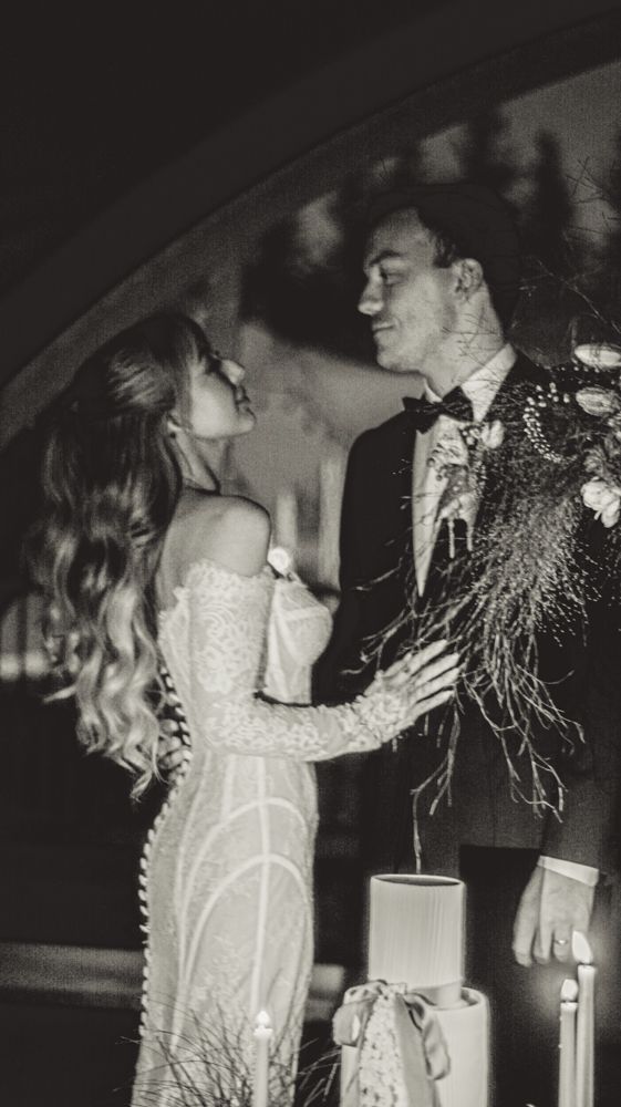 Black and white wedding photograph capturing an intimate moment under archway lighting.