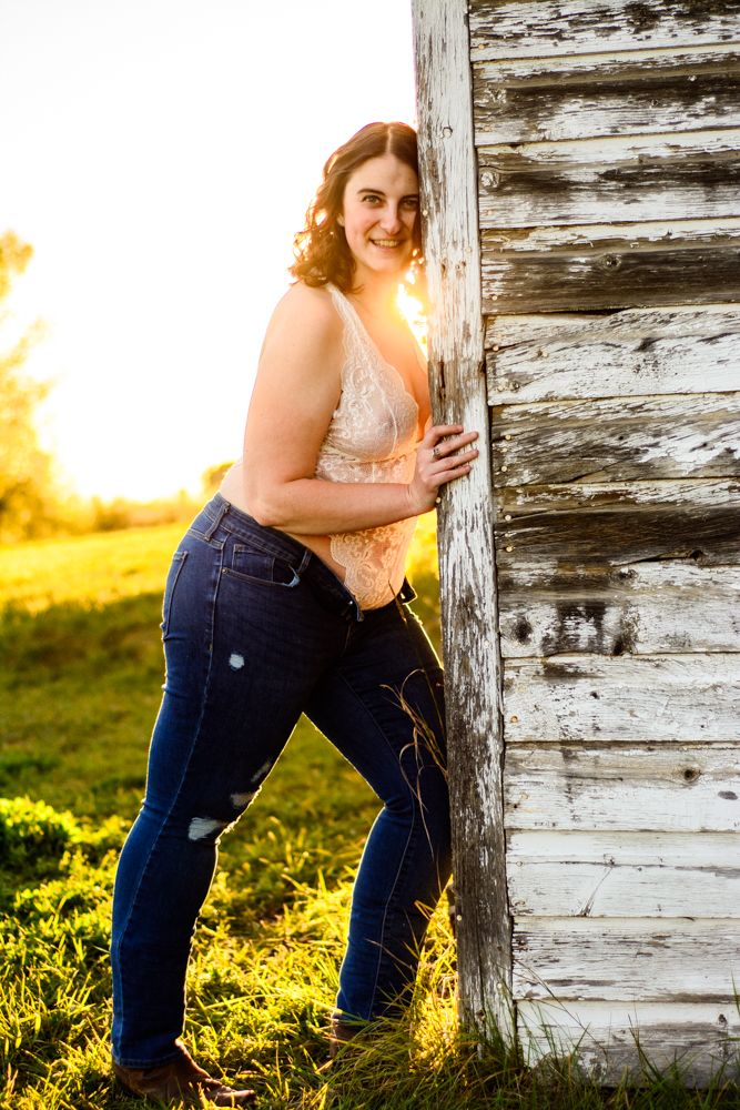 Casual lifestyle portrait against weathered barn siding at sunset.