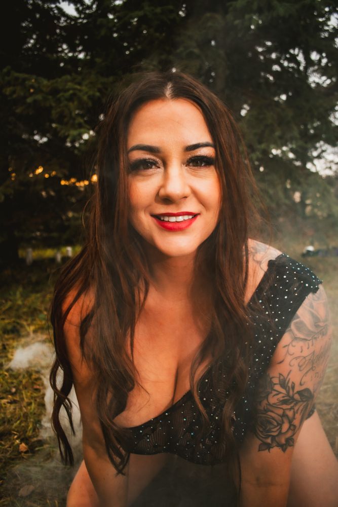 Outdoor portrait featuring sparkly black attire against trees with atmospheric effects.
