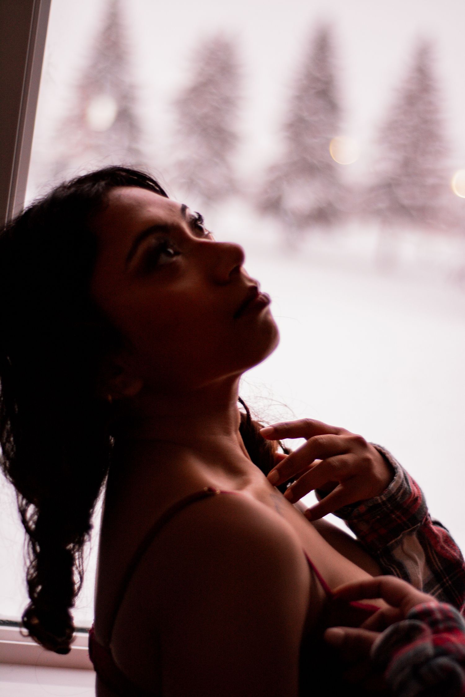 Elegant profile portrait with braided hair against snowy forest backdrop.