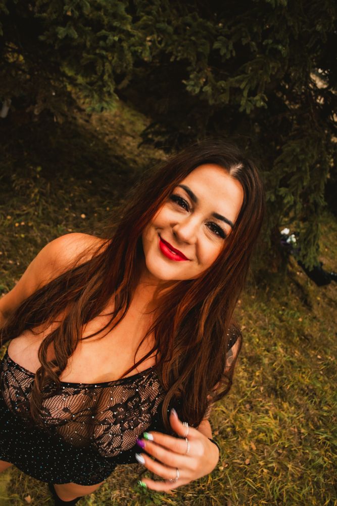 Outdoor fashion portrait with natural lighting and foliage backdrop.