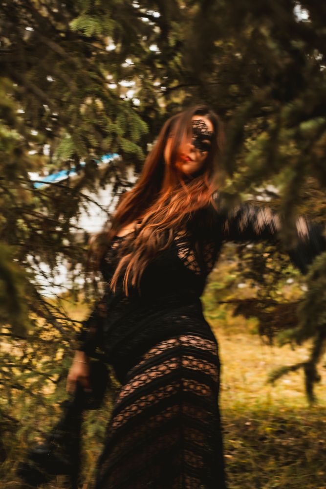 Ethereal motion shot in black lace dress against forest background.