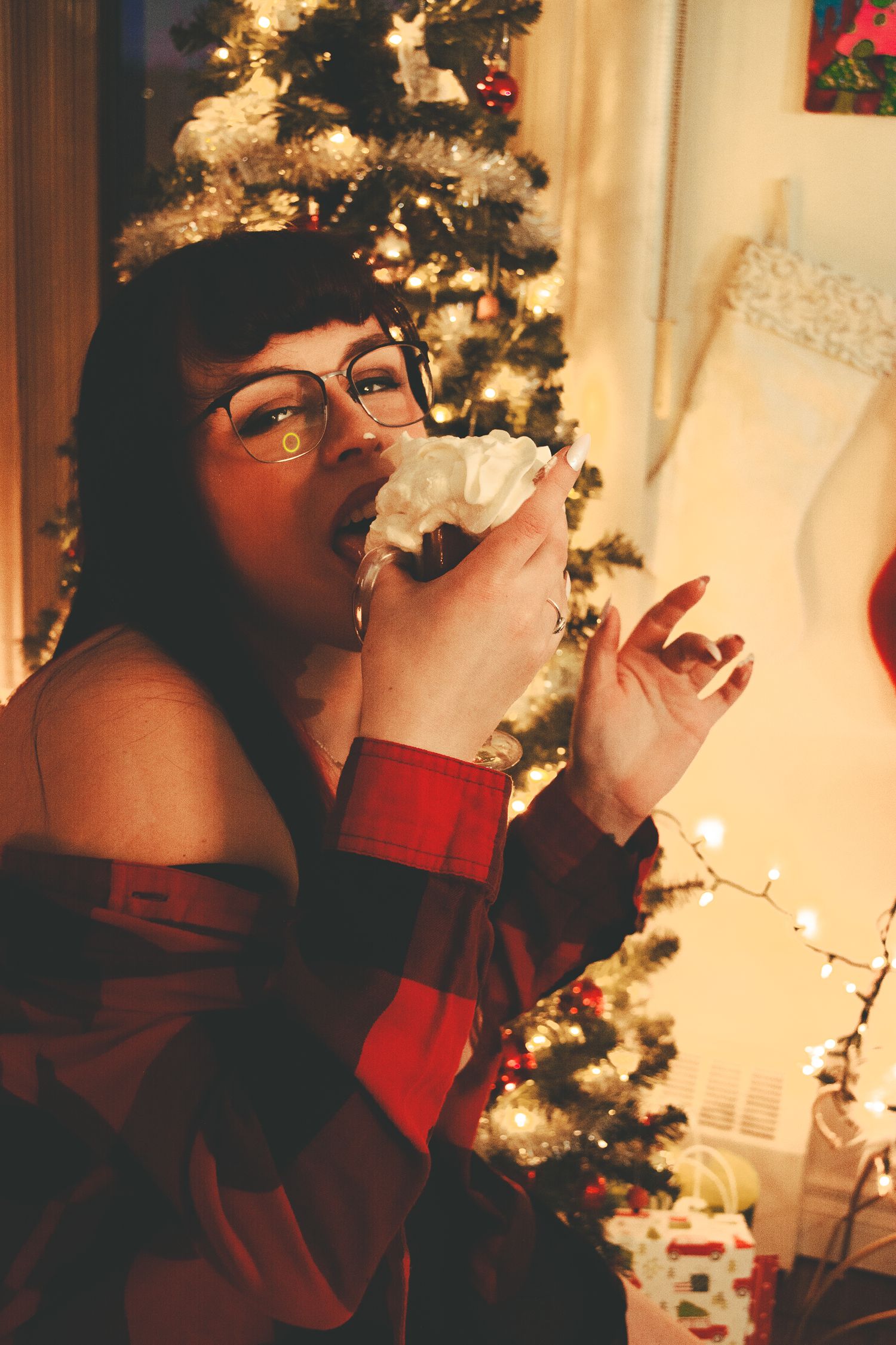 Cozy Christmas setting with red and white decor and a illuminated tree in the background.