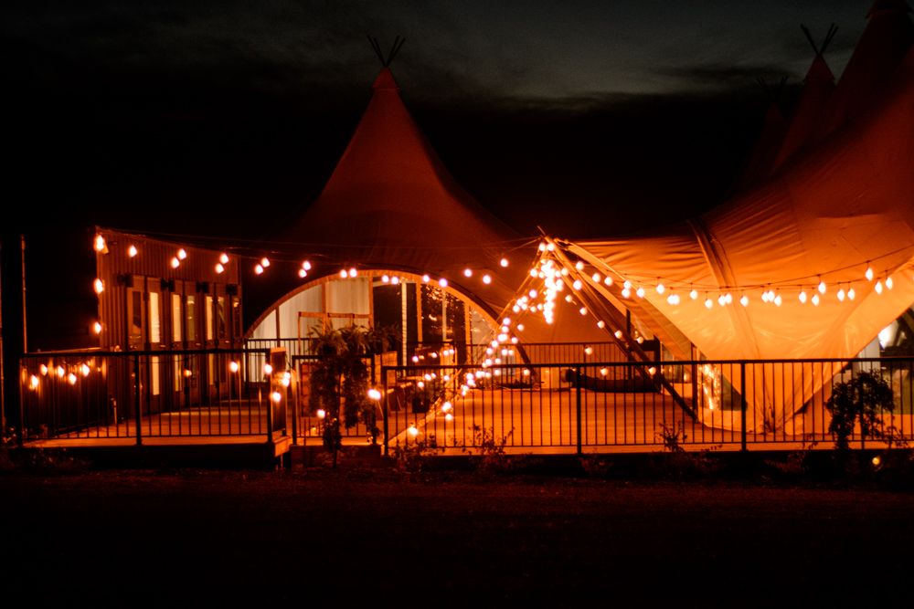 Wedding reception tent lit with string lights creating a magical evening atmosphere.