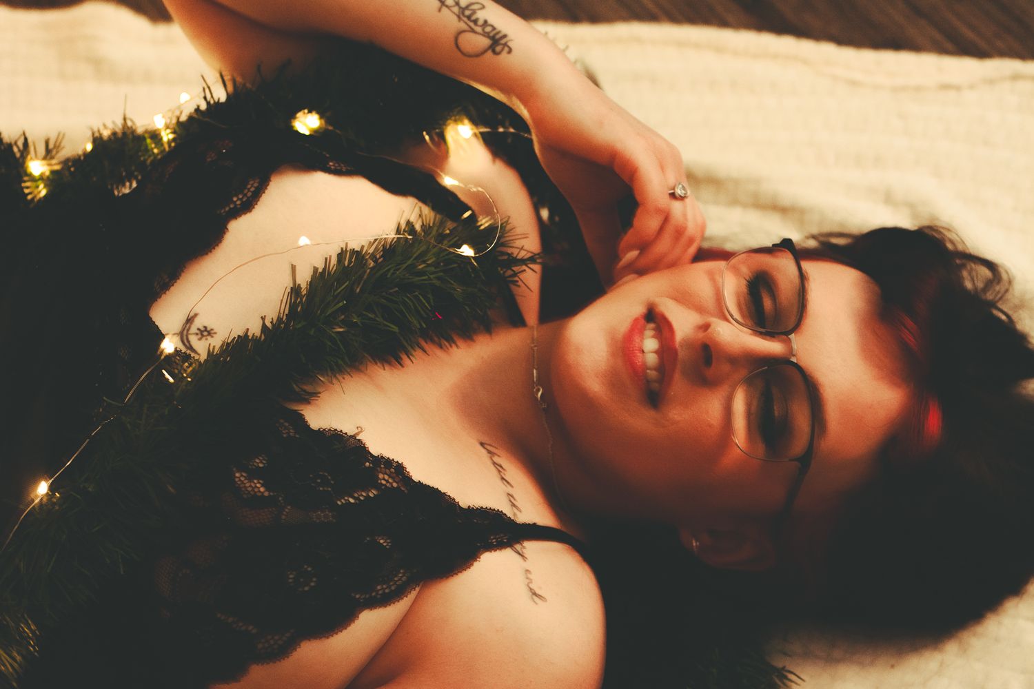 Intimate portrait with holiday decorations and string lights creating ambient glow.