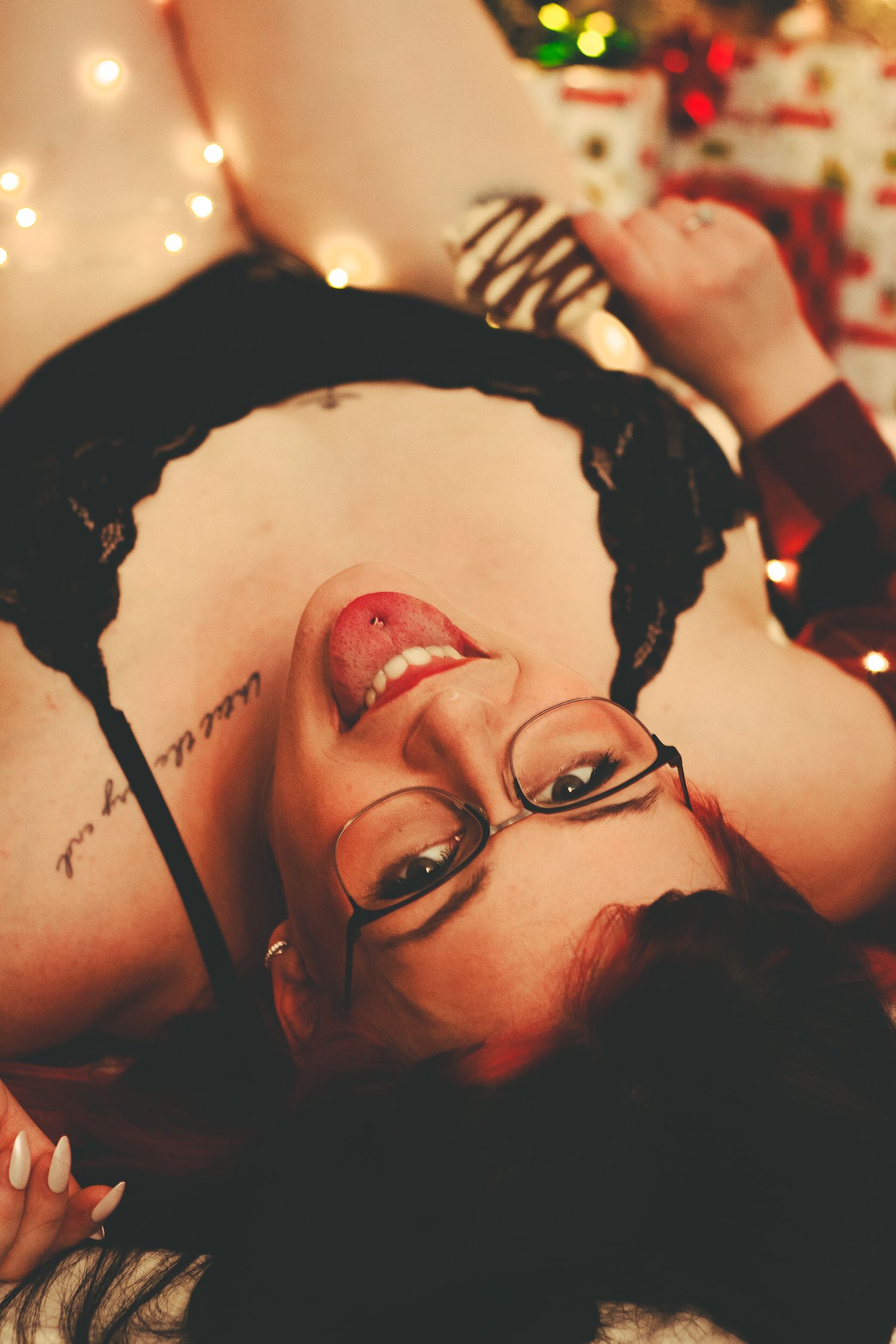 Glamour portrait with glasses and bold red lips in holiday setting.
