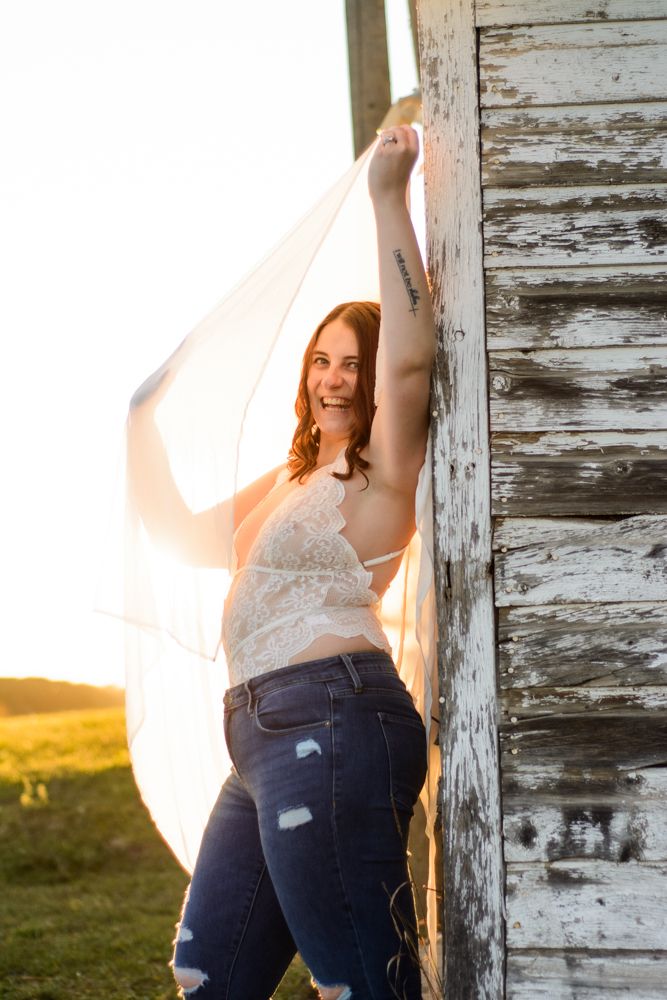 Artistic portrait against rustic weathered barn wood in golden hour lighting.