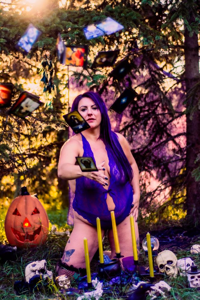 Mystical outdoor photoshoot with floating cards, candles and Halloween decorations.