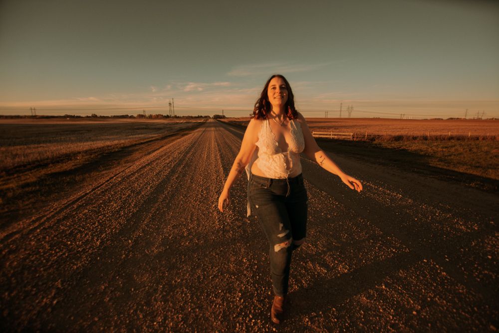Joyful movement captured on dusty rural road at sunset.