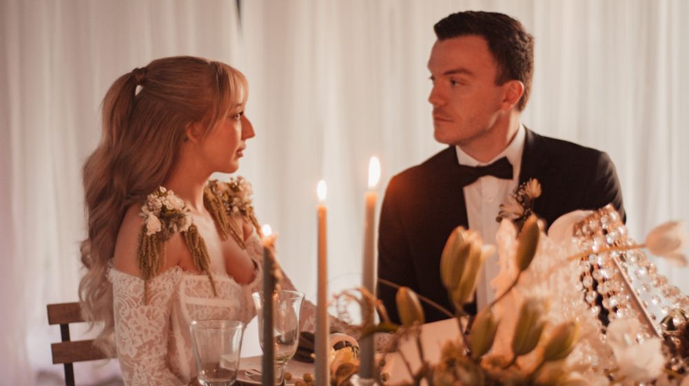Intimate reception dinner with candles and formal table settings.