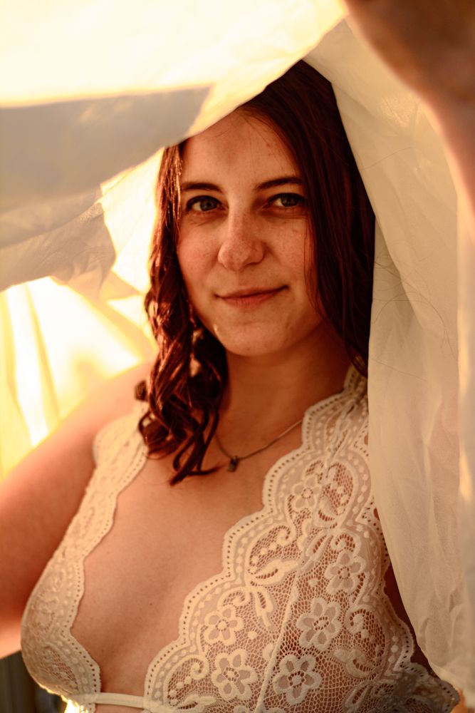 Intimate bridal portrait with lace details and soft veil during golden hour.